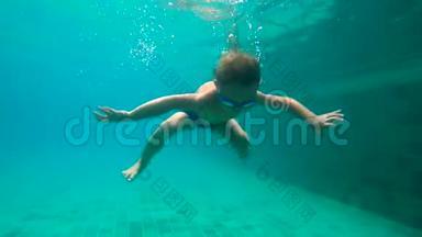 一个小男孩在水下拍摄的超HD慢动作学习如何在游泳池里游泳。 幼儿男孩潜入游泳池。
